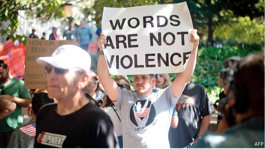 man holds up words are not violence sign